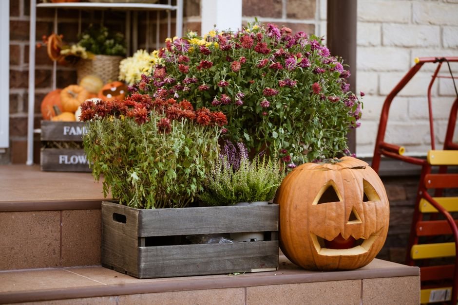 A charming autumn porch decorated for a Halloween basket delivery