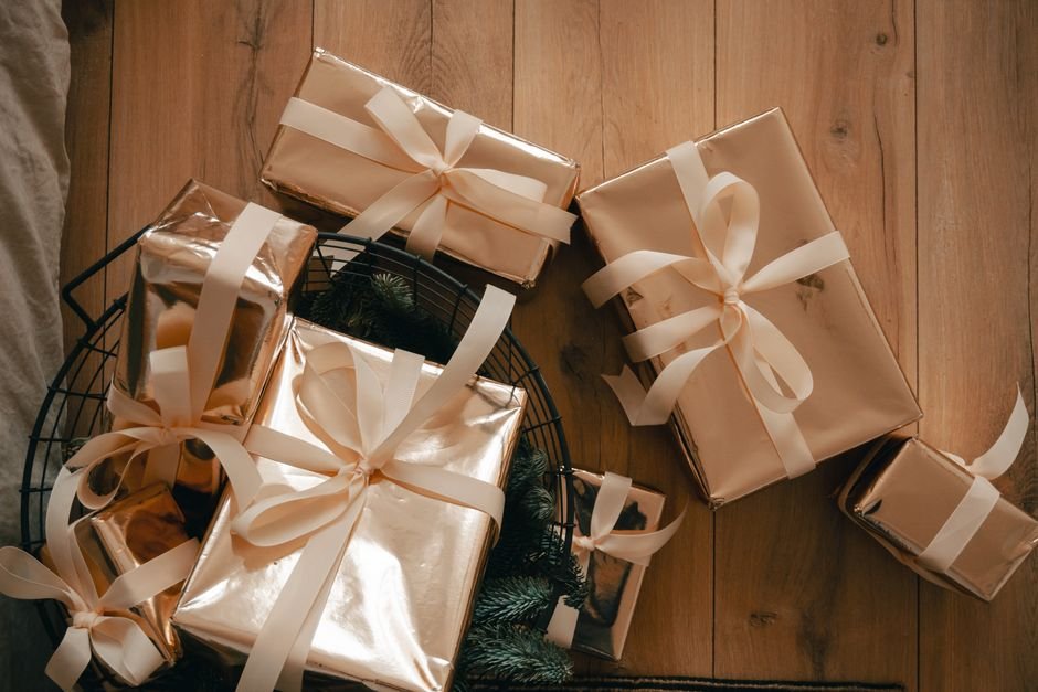 Wrapped gift baskets with ribbons on wooden floor