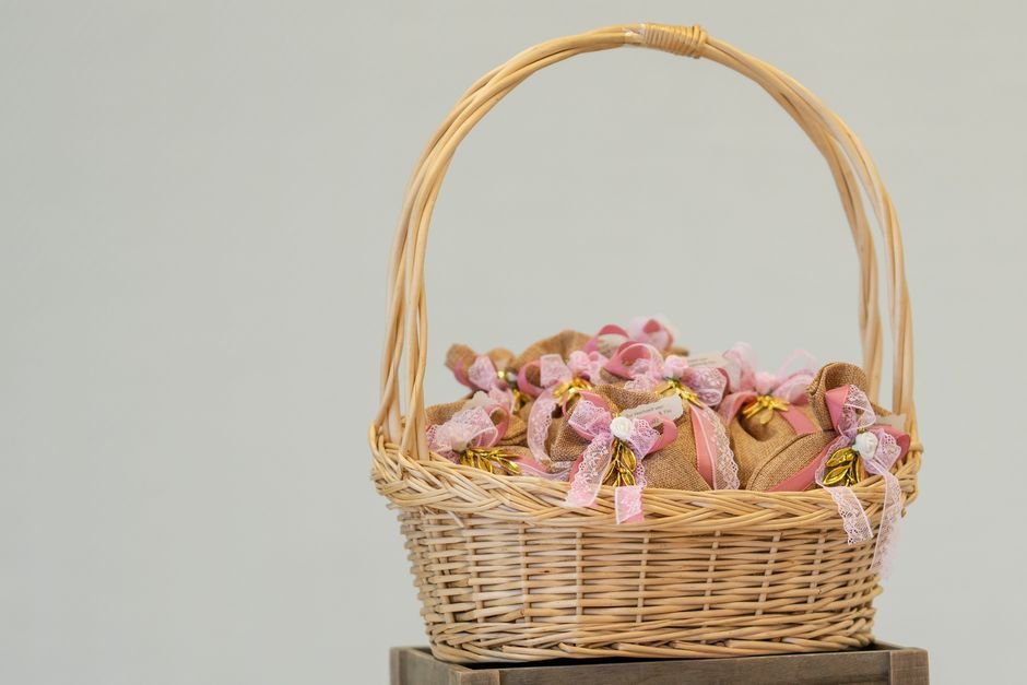 A wicker gift basket decorated with fabric bows