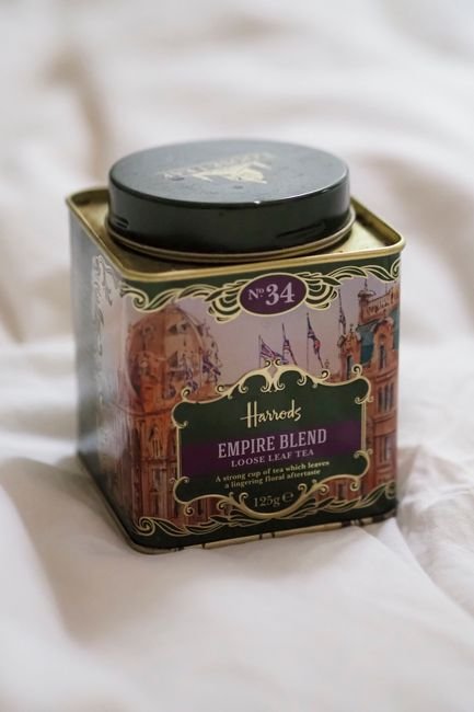 A premium tea tin resting on soft fabric as a close-up product shot