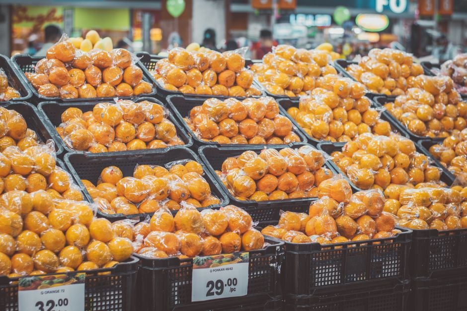 Fresh oranges wrapped in protective plastic