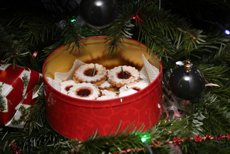 Christmas food gift cookies nestled in a red tin among tree branches
