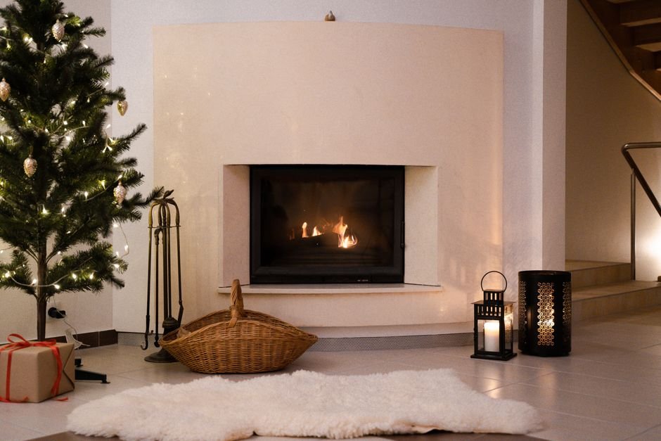 A cozy living room with a decorated Christmas tree and glowing fireplace, ready for gift baskets