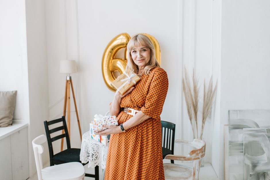 A woman smiling while holding a thoughtfully chosen birthday gift