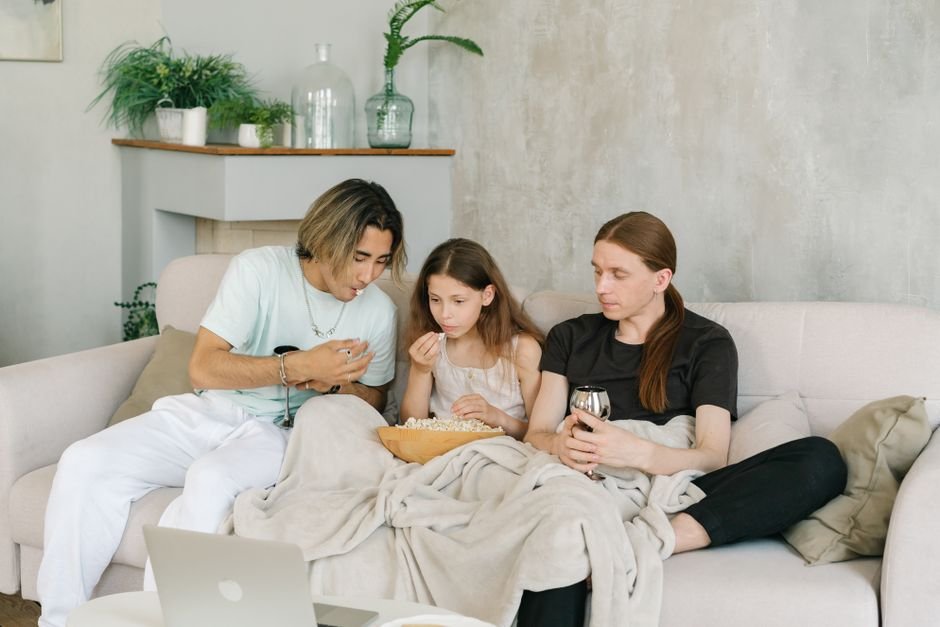 A family enjoying a movie night gift basket together on the couch