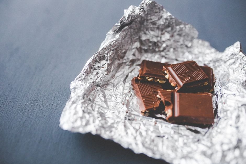 A chocolate bar unwrapped from foil, similar in style to Ghirardelli Squares