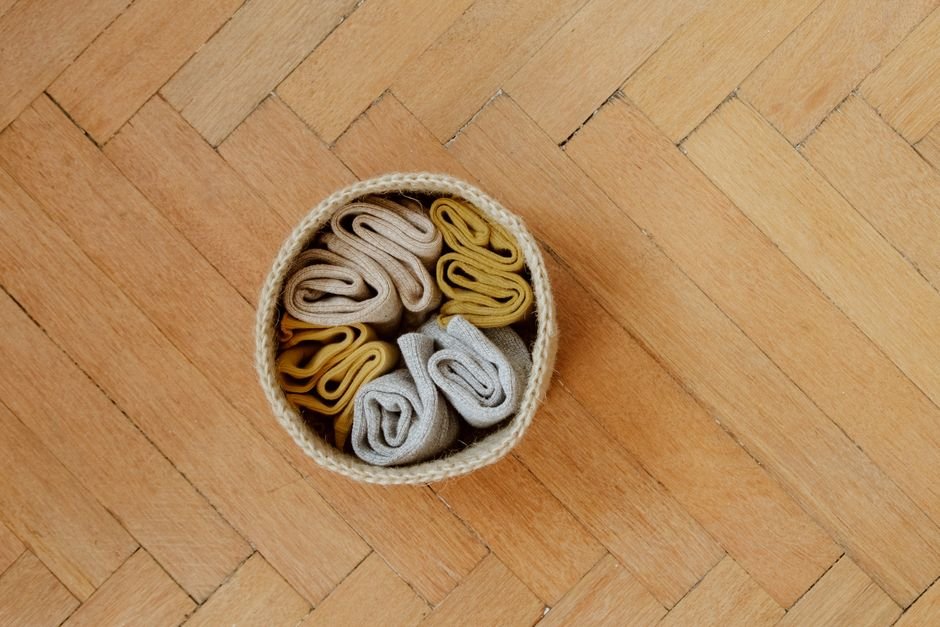 Rolled wool socks in a basket for a cozy hygge gift