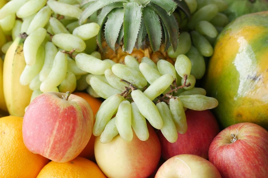 Assorted fresh fruit including grapes and pineapple arranged for a fruit gift hamper