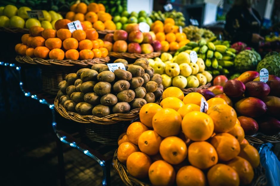 Farmers market display of fresh organic fruit including kiwis and oranges