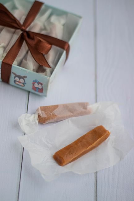 Wrapped caramel candy presented in a gift box with ribbon