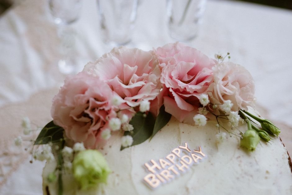 Pink floral birthday cake with a Happy Birthday topper for a 50th birthday celebration