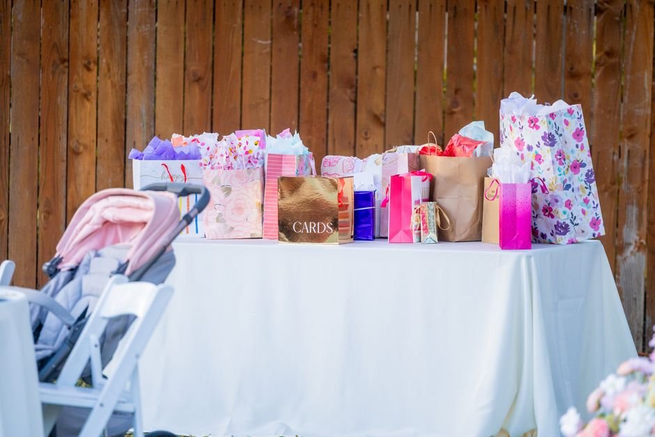 Baby shower gift table with wrapped presents and gift bags