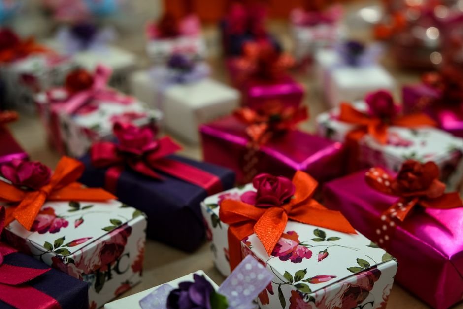A wrapped gift box with roses beside a bridesmaid proposal card, ready to give to a friend