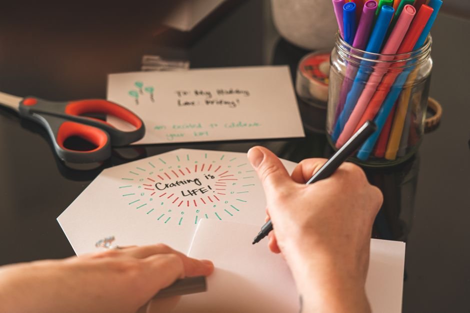 A person handwriting a heartfelt note, the kind of care that goes into an engagement card