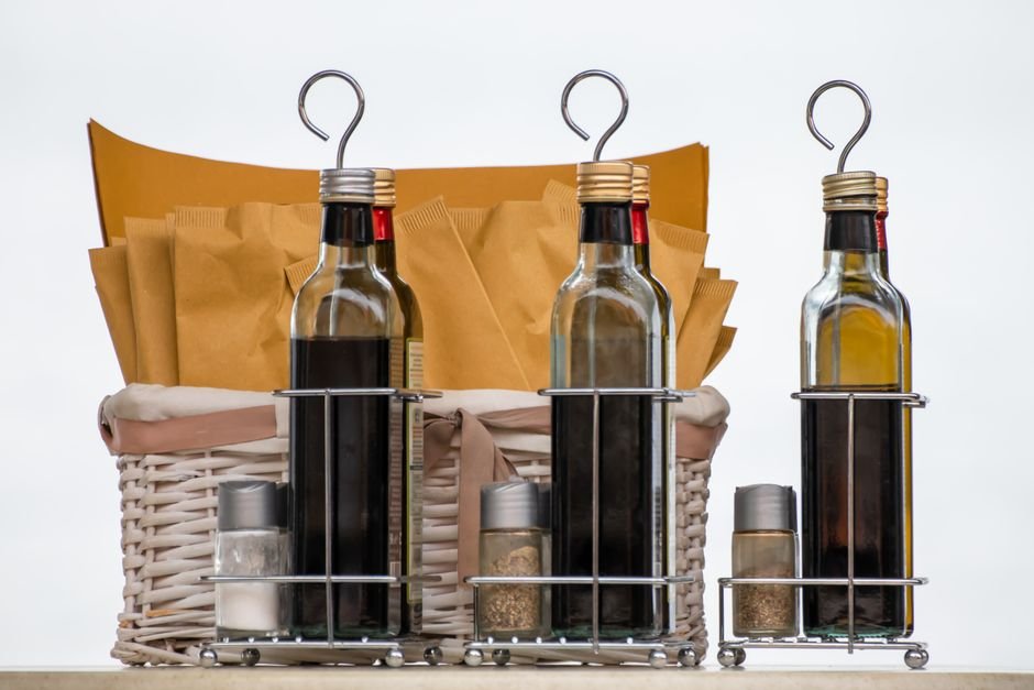 Olive oil and vinegar bottles in a wicker gift basket for someone who likes to cook