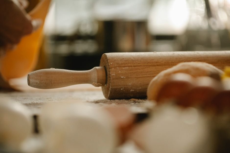A rolling pin and fresh dough on a floured table, a classic pick among gift ideas for bakers
