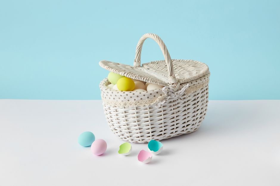 White wicker Easter basket with pastel eggs