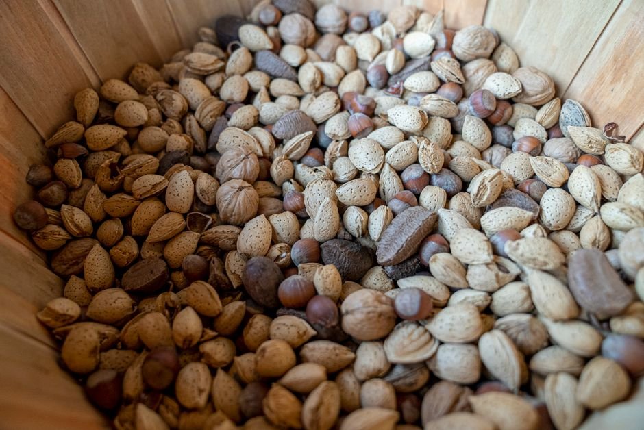 Assorted whole nuts arranged in a wooden healthy snack gift basket