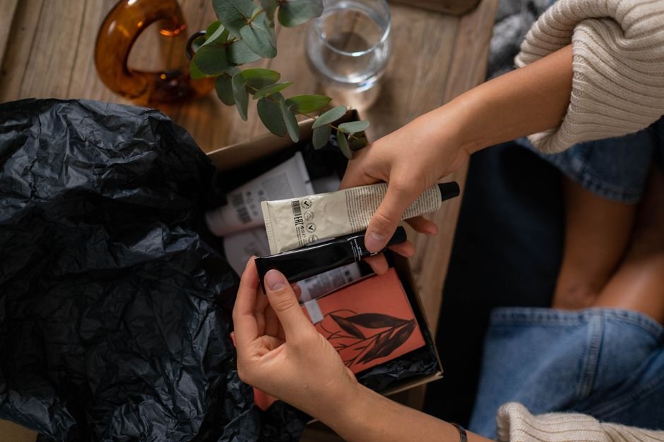 Hands unboxing a subscription box with skincare products