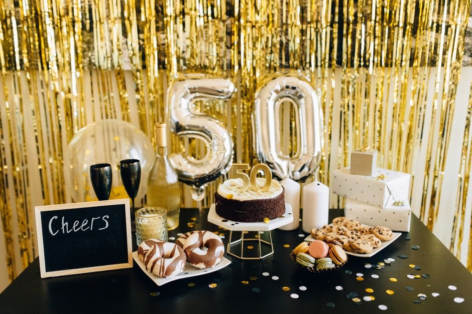 Stylish 50th birthday party setup with gold balloons and gifts