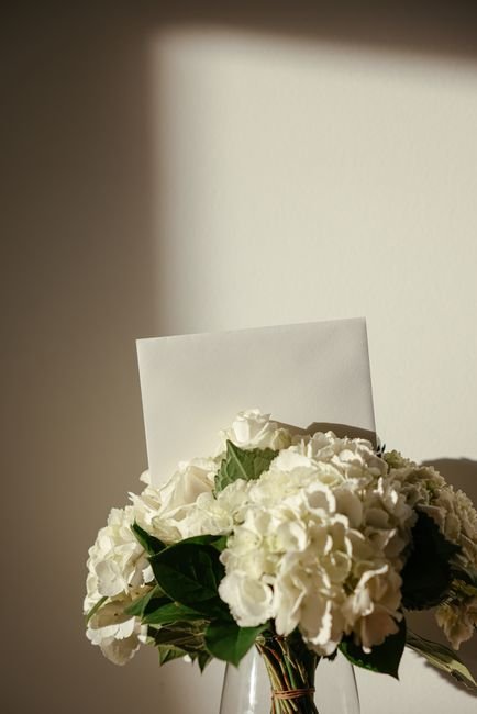 Bouquet of white flowers beside a blank sympathy card